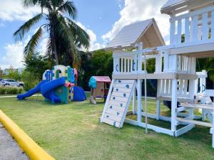 um parque infantil com um escorrega e uma estrutura de jogos em Thematic beach apartment in CapCana area em Punta Cana