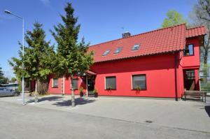 un edificio rojo con techo rojo en Pensjonat Paskal, en Czerlejno