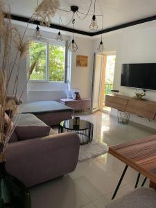 a living room with a couch and a tv at MarElla Bačvice Beach Apartment in Split