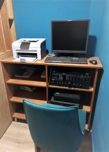 a desk with a computer and a monitor and a chair at Luander Hotel in Tirana