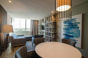Protea Hotel by Marriott Durban Umhlanga في ديربان: غرفة معيشة مع طاولة وكراسي