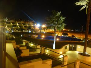 a view of a hotel at night with palm trees at Casa Valdevaqueros in Tarifa