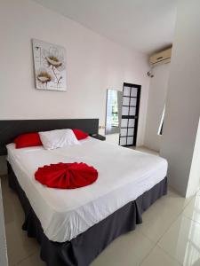 a bedroom with a large bed with a red flower on it at HOTEL AMASH Chone in San Pablo