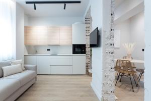 a white living room with a couch and a table at Meraki Suites in Astorga