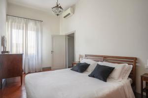 a bedroom with a white bed with two blue pillows at Apartment with terrace facing Duomo in Florence