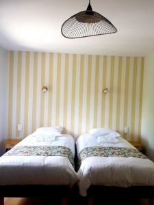 2 Betten nebeneinander in einem Zimmer in der Unterkunft CoGîte A Condat in Le Grand-Bourg