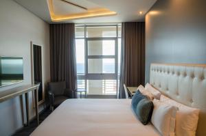 a hotel room with a large bed and a window at Protea Hotel by Marriott Durban Umhlanga in Durban