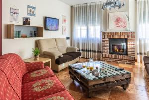 een woonkamer met een bank en een open haard bij Gran apartamento a 55 min de Madrid confort, calidad & salón de tertulias in Segovia