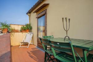 une table et des chaises vertes sur la terrasse dans l'établissement Apartment with terrace facing Duomo, à Florence
