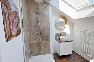 uma casa de banho com um chuveiro, um lavatório e um espelho. em Le ciel étoilé, Belfort ville em Belfort
