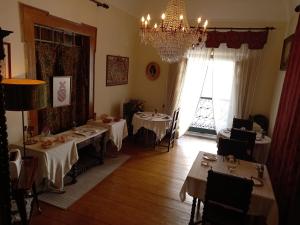 een eetkamer met 2 tafels en een kroonluchter bij Casa De S. Tiago in Évora