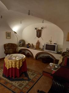 een woonkamer met een tafel en een televisie bij Casa De S. Tiago in Évora