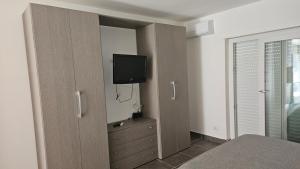 a bedroom with a closet with a tv on the wall at Pescasubacquea in Crotone