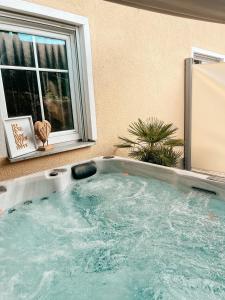 a jacuzzi tub in front of a window at Panorama-Refugium in Bad Koetzting