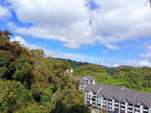 Une rangée de maisons sur une colline avec des arbres dans l'établissement Dream4 @ emerald avenue, à Brinchang