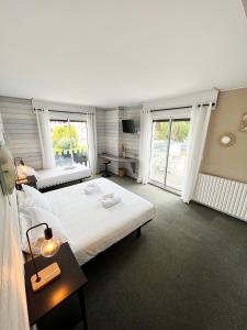 a bedroom with two beds and a large window at Diu Biban in Hossegor