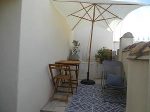 eine Terrasse mit einem Tisch und einem Sonnenschirm in der Unterkunft Studio 2 personnes à Moussan in Moussan