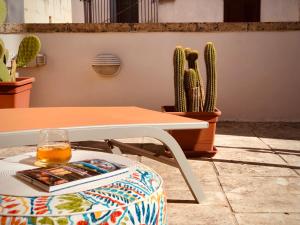 a table with a drink on a stool next to a cactus at Artas la tua casa indipendente a Lecce in Lecce