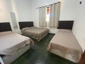 Zimmer mit 2 Betten und einem Fenster in der Unterkunft Linda casa Condomínio Costa do Sol - Bertioga in Bertioga