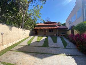 a house with a tile roof and a yard at Linda casa Condomínio Costa do Sol - Bertioga in Bertioga
