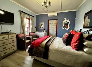 ein Schlafzimmer mit einem Bett und einem Stuhl und einem Fernseher in der Unterkunft A State of Grace in Clanwilliam + 47 Fotos