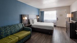 a hotel room with a bed and a couch at SureStay Hotel by Best Western Virginia Beach Royal Clipper in Virginia Beach +23 photos