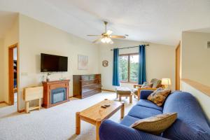 a living room with a blue couch and a tv at Richville Vacation Rental with Fire Pit Near Trails in Ottertail