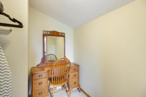 a wooden dresser with a mirror and a wooden chair at Richville Vacation Rental with Fire Pit Near Trails in Ottertail