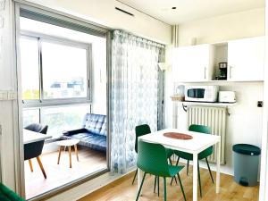 une petite cuisine avec une table et des chaises ainsi qu'une fenêtre dans l'établissement Caporizon-Cap 239-Vue Mer-T1 à 50m Plage, à La Rochelle