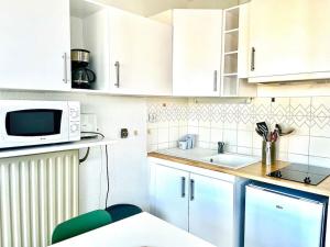- une petite cuisine avec des placards blancs et un four micro-ondes dans l'établissement Caporizon-Cap 239-Vue Mer-T1 à 50m Plage, à La Rochelle
