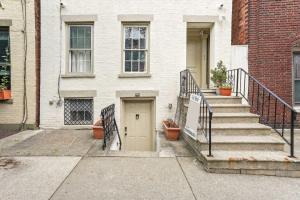 a white house with stairs and a door at Downtown Albany Apartment Walk to Capitol! in Albany