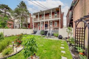 a garden in front of a brick house with a fence at Harrisburg Hideaway with Yard about 2 Mi to Downtown in Harrisburg