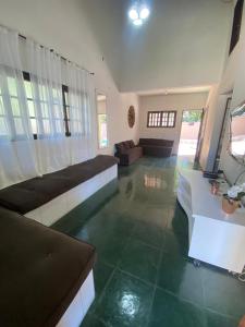 ein Wohnzimmer mit grünen Fliesenböden und einem Sofa in der Unterkunft Linda casa Condomínio Costa do Sol - Bertioga in Bertioga