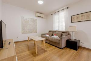 Alcam Laforja في برشلونة: غرفة معيشة مع أريكة وطاولة