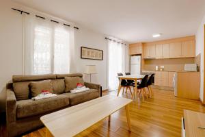 a living room with a couch and a kitchen at Alcam Laforja in Barcelona