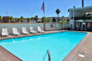 a swimming pool with lounge chairs next to a building at Americas Best Value Inn Loma Lodge in San Diego