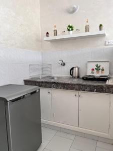 a kitchen with white cabinets and a counter top at Studio de charme rénové - Fibre- Centre Rabat in Rabat