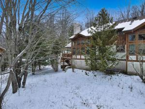 ein Haus mit Schnee auf dem Boden davor in der Unterkunft 679 Disciples Village Unit in Boyne Falls