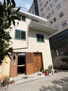 a house with a wooden door and some plants at Dedi Apartment 2 in Shkodër