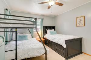 a bedroom with two bunk beds and a ceiling fan at Rogers Vacation Rental about 7 Mi to Downtown in Rogers