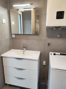 ein Badezimmer mit einem weißen Waschbecken und einem Spiegel in der Unterkunft Markioli Residence in Sevid