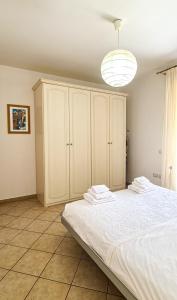 a bedroom with a large white bed and a light at Le Cave Apartment in Sirolo