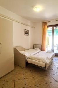 two twin beds in a room with a window at Le Cave Apartment in Sirolo