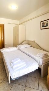 two beds in a room with towels on them at Le Cave Apartment in Sirolo