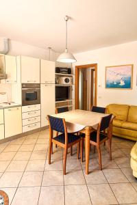 a kitchen and living room with a wooden table and chairs at Le Cave Apartment in Sirolo