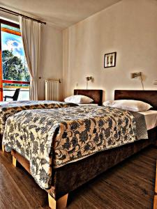 a hotel room with two beds and a window at Hotel Villa Siesta in Smokovce