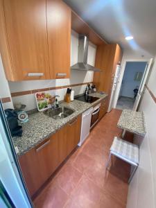 a small kitchen with wooden cabinets and a sink at Vistas al mar -Torre del mar- HOME RENT MALAGA in Vélez-Málaga