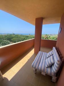 een balkon met een bank en een groot raam bij A&C Vistas al mar -Torre del mar - Malaga in Vélez-Málaga