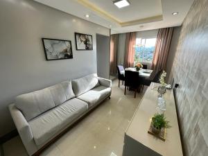 uma sala de estar com um sofá e uma mesa em Lindo Apartamento Inteiro Proximo ao Centro de Criciuma em Criciúma