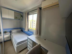 um pequeno quarto com uma cama e uma janela em Lindo Apartamento Inteiro Proximo ao Centro de Criciuma em Criciúma